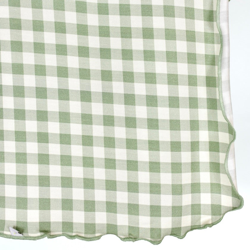 An evergreen lane / swaddle in sage green and white gingham with a scalloped edge.