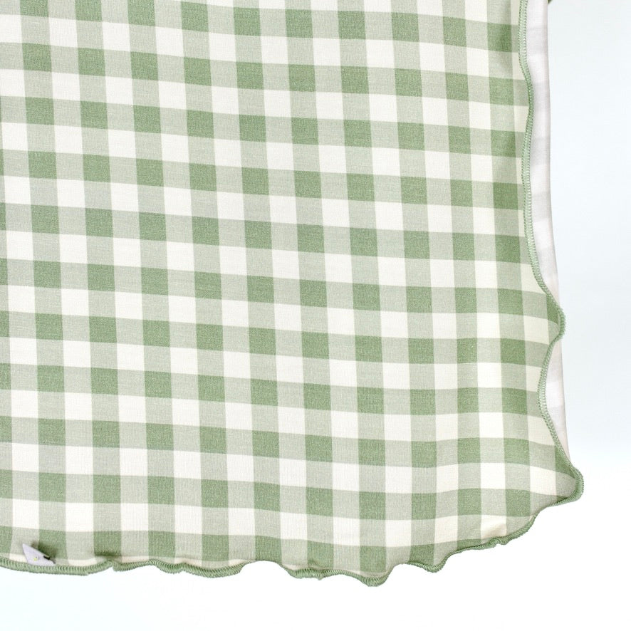 An evergreen lane / swaddle in sage green and white gingham with a scalloped edge.