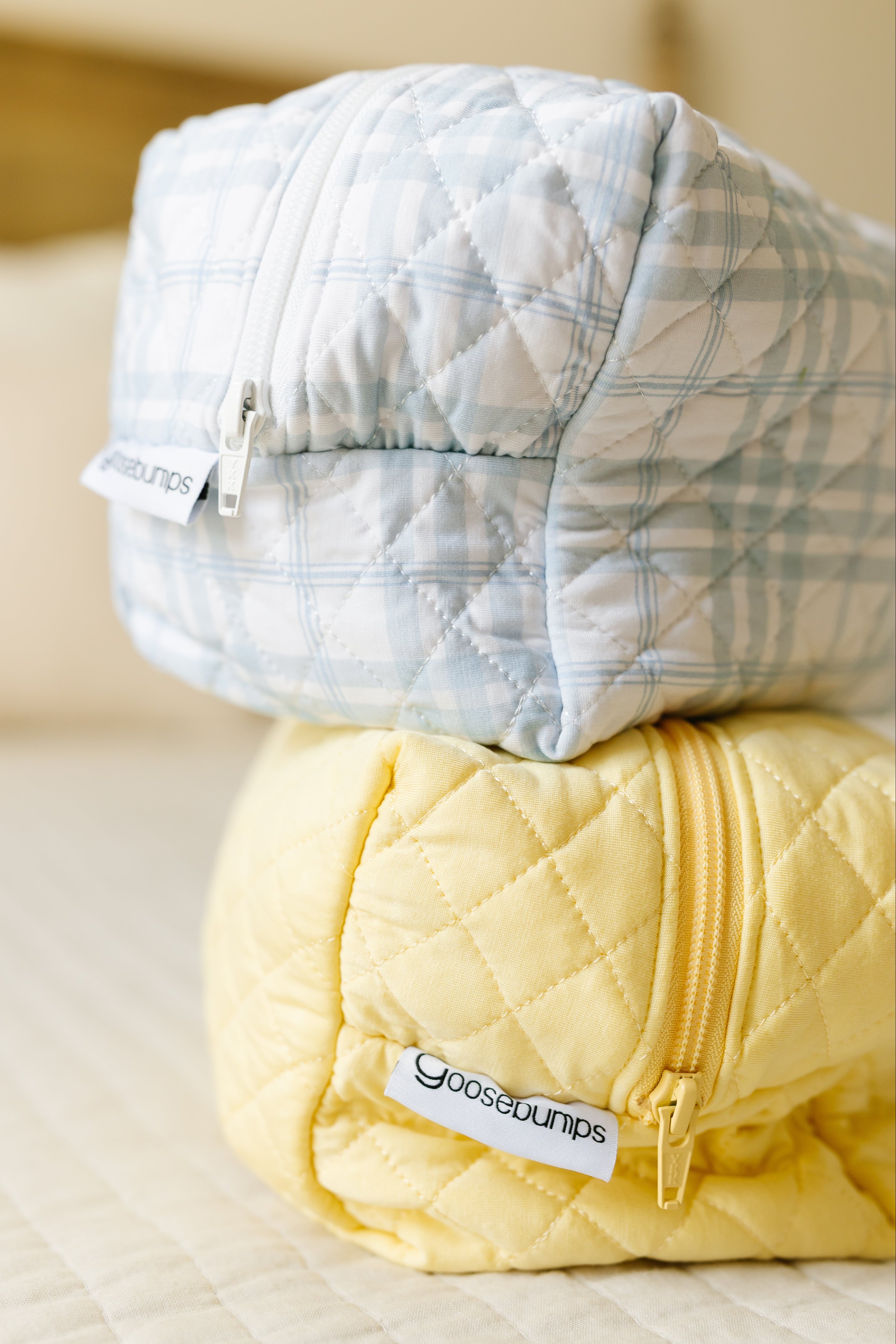 The lemon meringue / travel bag set includes light blue and yellow quilted pouches with matching zippers, each featuring a Goosebumps Travel Bag tag—ideal as stylish travel accessories.