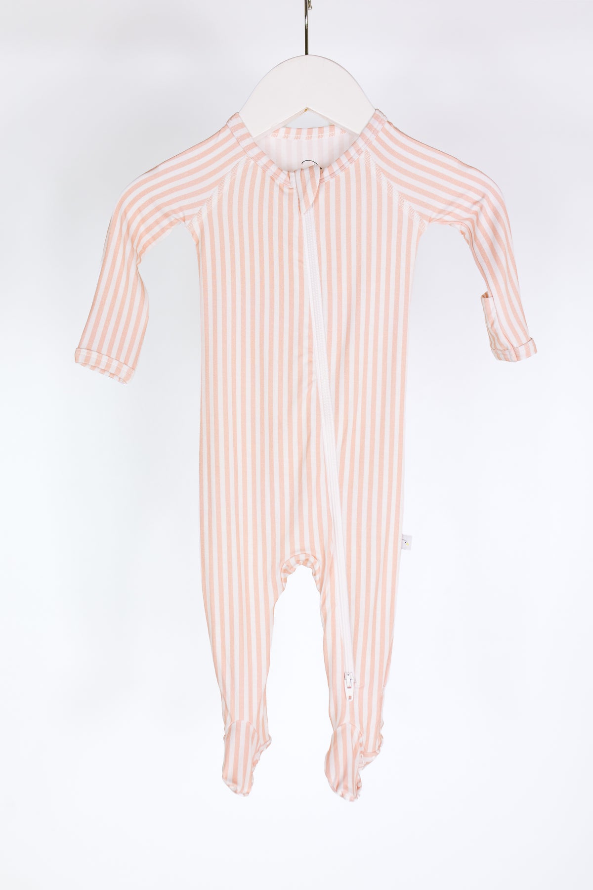 A heritage / one piece zipper baby onesie in pink and white stripes with long sleeves and footed legs, crafted from cozy bamboo fabric and featuring a convenient two-way zipper, shown on a white hanger against a plain white background.