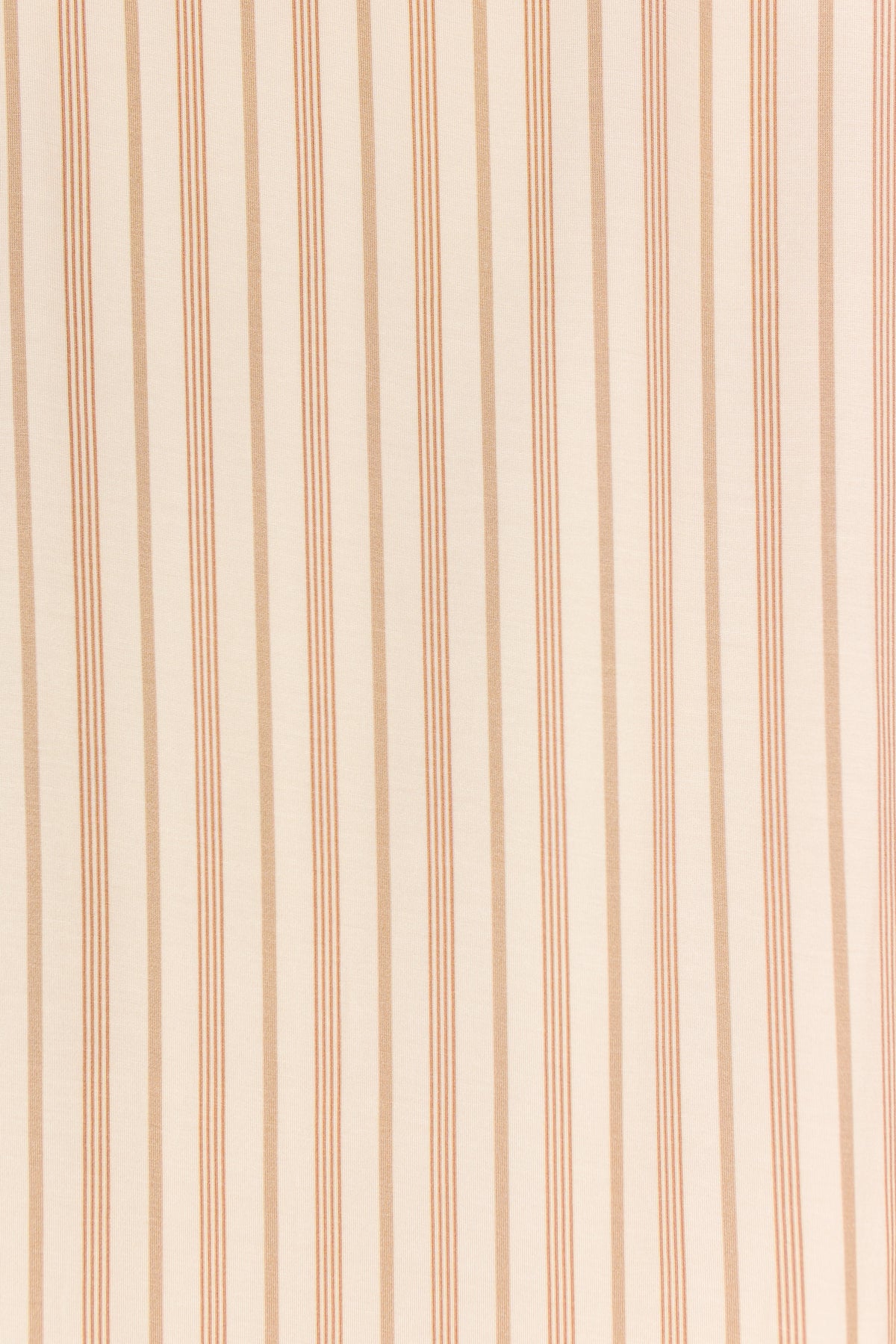 Sure! Here’s a rewritten version of your sentence using the provided product data: The toast and honey / swaddle features a smooth bamboo textile in beige, highlighted by a vertical pattern of evenly spaced thin and wide brown stripes for a simple, symmetrical, and classic tan-and-cream stripe look.