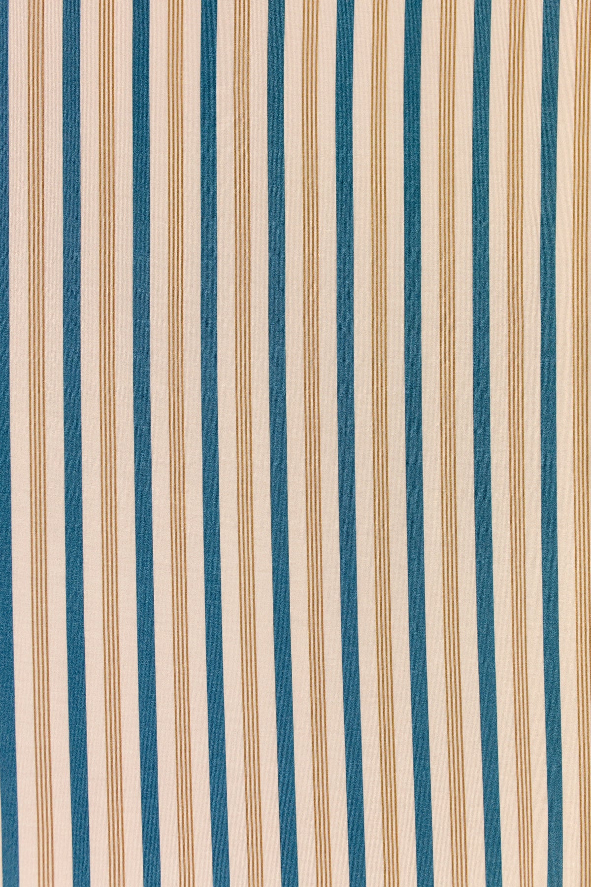 Shoreline / swaddle features vertical blue and tan stripes of varying thicknesses on a beige background, creating a repeating pattern reminiscent of a classic striped baby blanket—perfect for bringing a gentle, soothing touch to any nursery décor.
