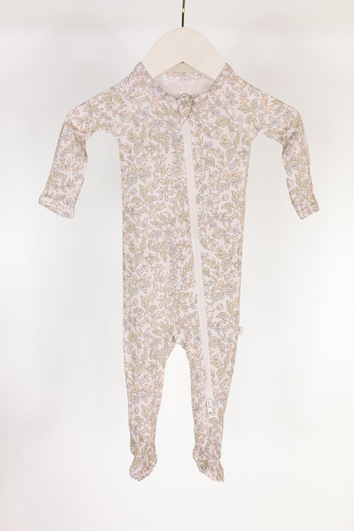A long-sleeve heirloom / one piece zipper with a leafy floral pattern and a diagonal zipper, displayed on a white hanger against a plain white background. Perfect as bamboo newborn pajamas or cozy footed pajamas for your little one.