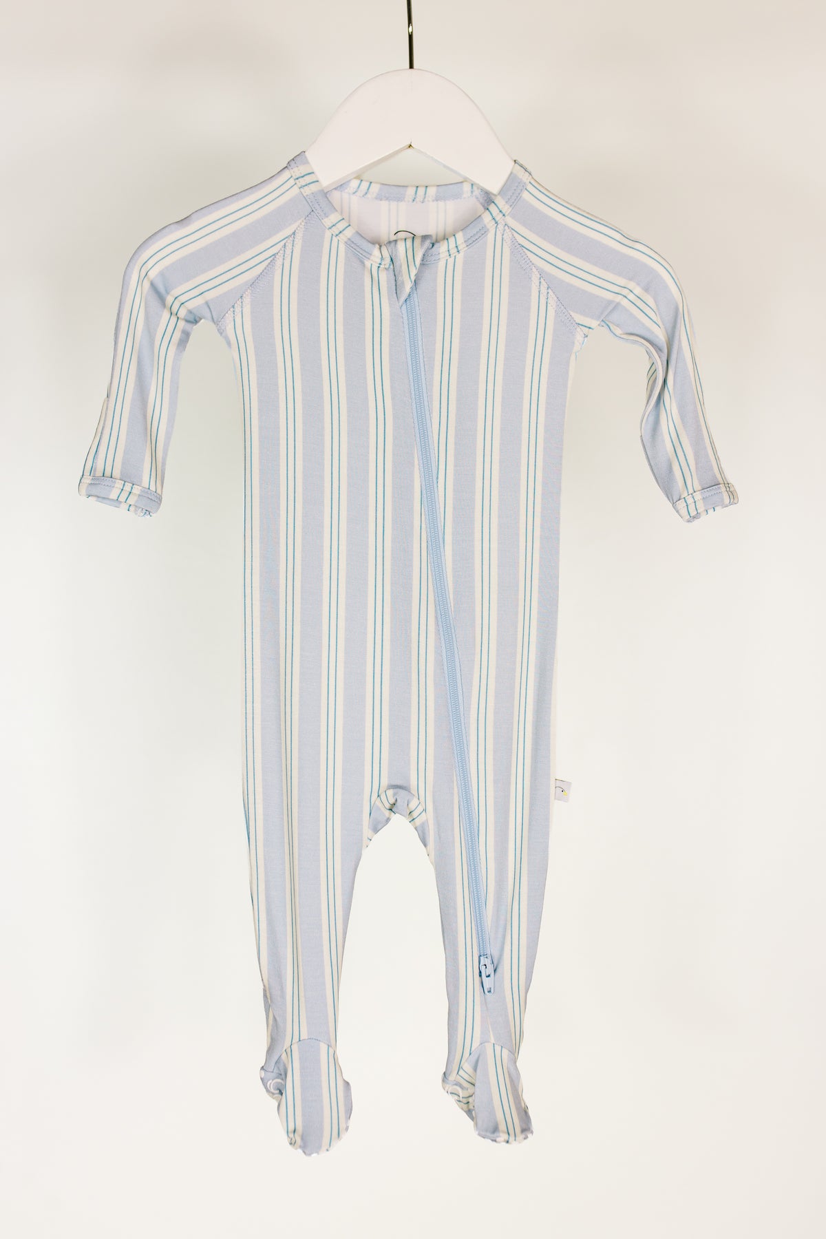 A haven / one piece zipper baby sleeper in light blue and white stripes, made from soft bamboo, with long sleeves, covered feet, fold-over mittens, and a convenient diagonal zipper closure from the collar to one leg—perfect as a cozy newborn one-piece outfit.