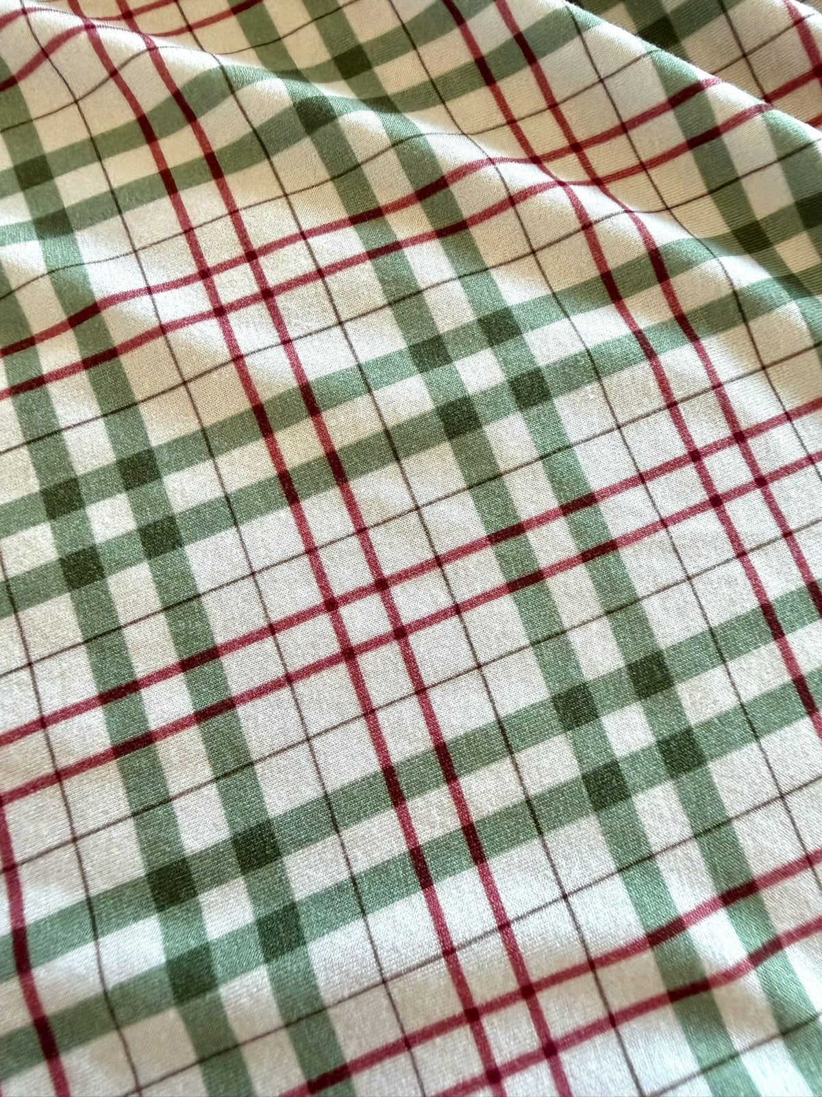 Homestead / two piece skinny kids pajamas in a red and green plaid fabric.