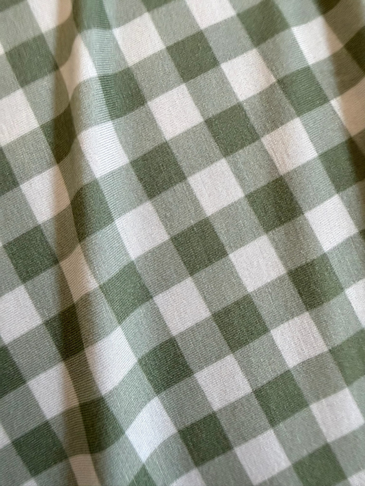 Sage green and ivory gingham patterned fabric on an evergreen lane / travel bag.