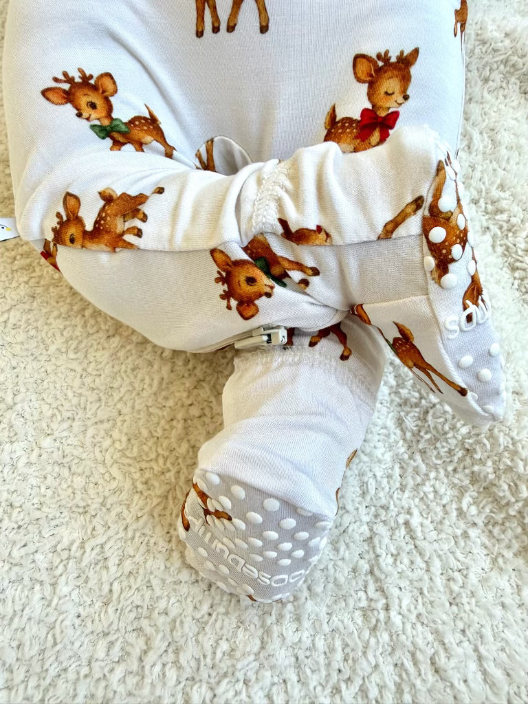 Vintage reindeer one piece zipper infant bamboo baby sleeper in white with a repeating vintage reindeer print featuring cartoon reindeer wearing green and red bows.