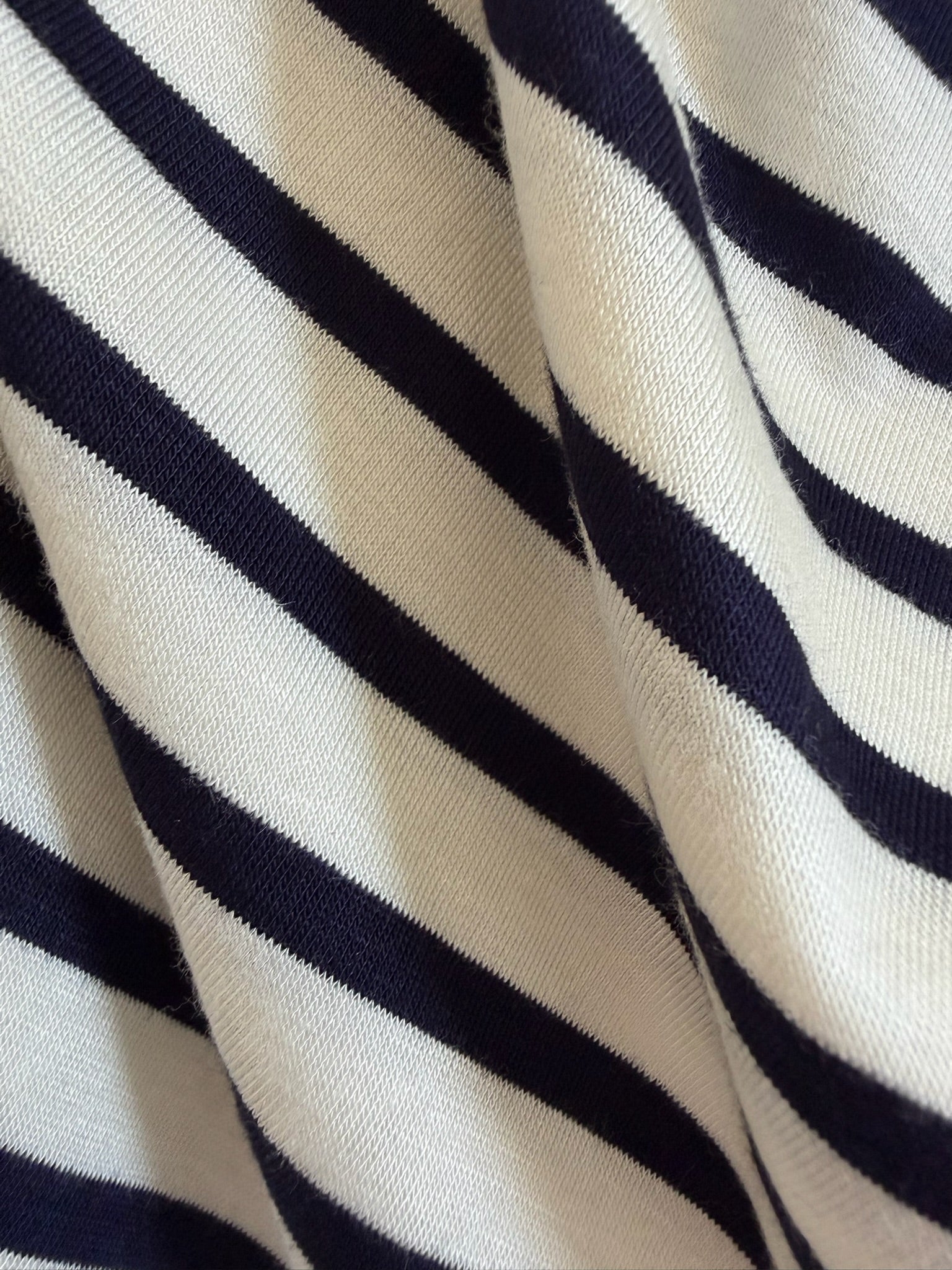 Close-up of the Bayside blanket featuring diagonal black and white stripes, highlighting its texture and folds.