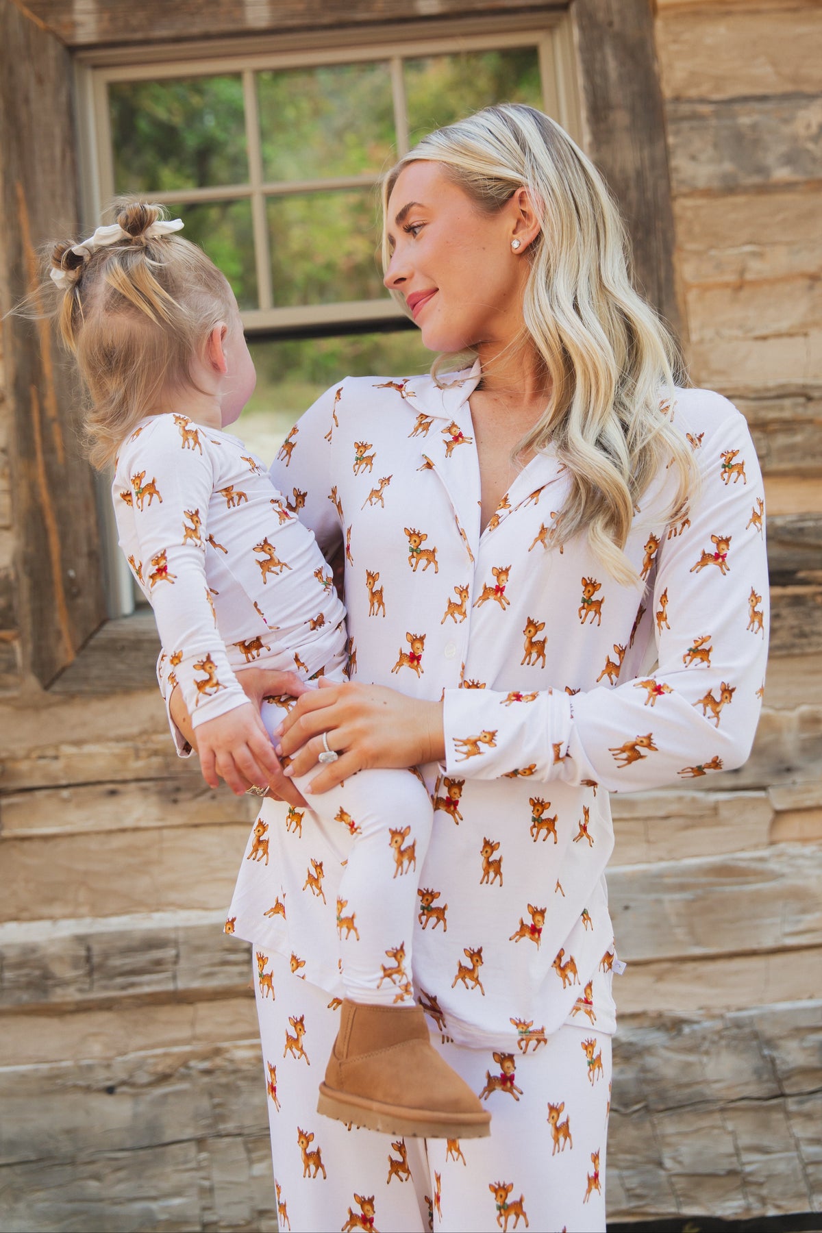 A woman and young child wearing matching vintage reindeer pajama set with long pants.