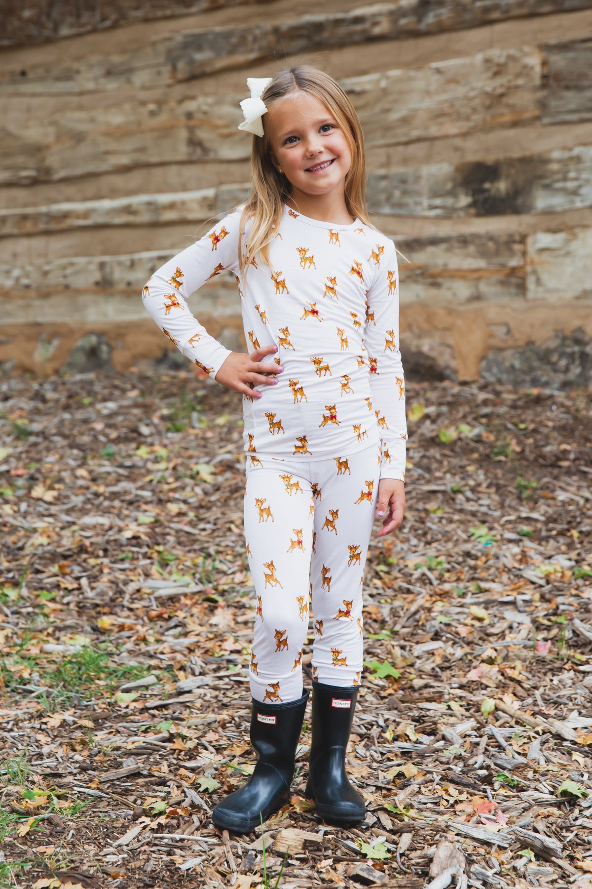 A young girl wears the vintage reindeer / two piece skinny, paired with black rubber boots.